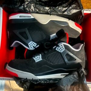 Slightly worn Jordan 4 Retro “breds” or black and red colorway